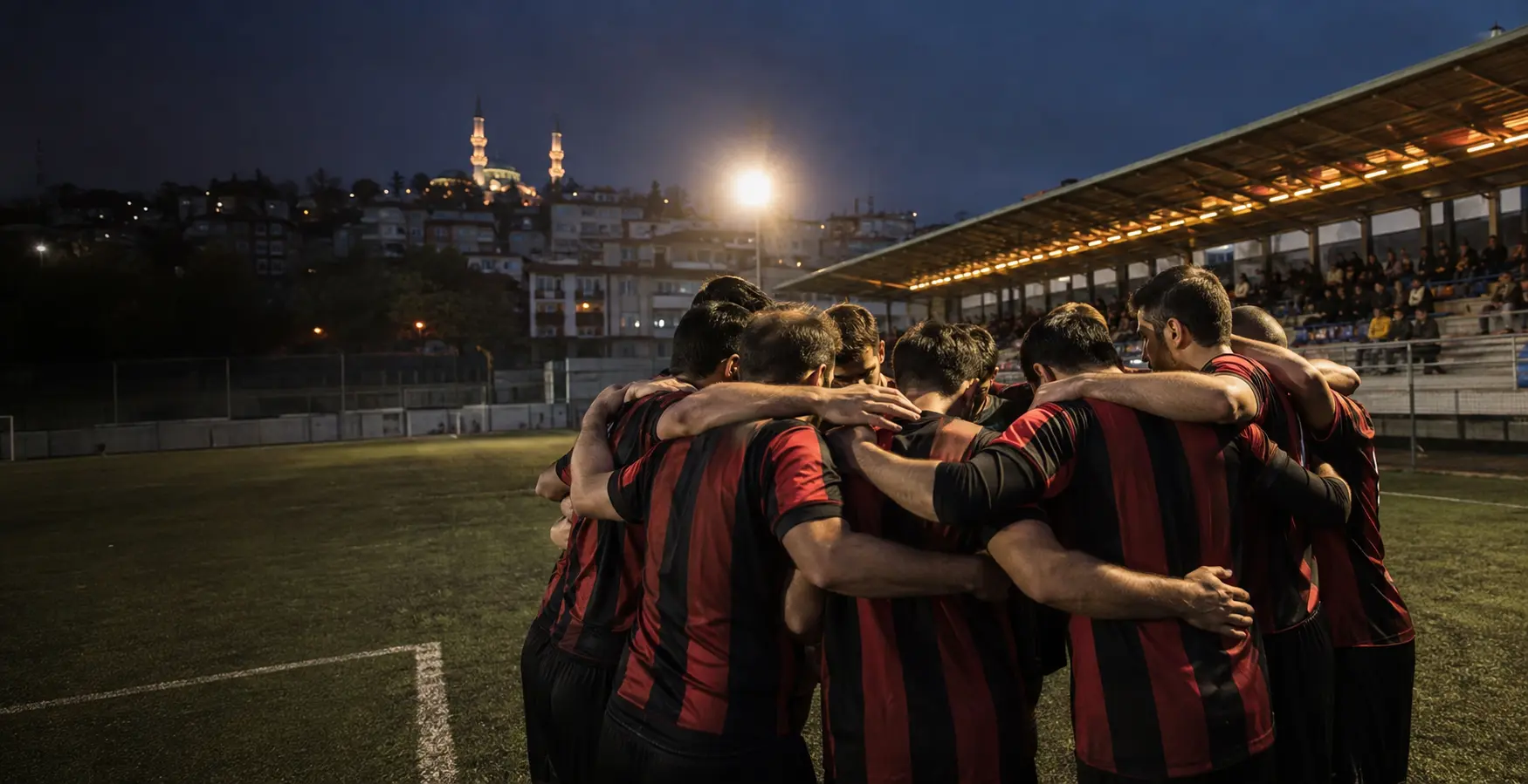 Siyah kırmızı formalı futbolcular maç öncesi takım çemberinde